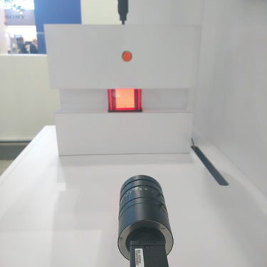 The Sony XCG-CP510 camera pointed at a perspex block under stress. Stress is altered via the adjustable screw (black rod above), light is shone through the block, with areas under stress bending the angle of light.
