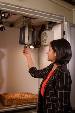Figure 2: Amrita Sahu makes adjustments to the lens of a hyperspectral imaging system used to grade agricultural products.