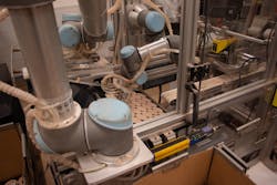 Figure 2: Universal Robots UR3 and UR5 arms pick and place the godets onto trays and cases respectively. Figure 2: Universal Robots UR3 and UR5 arms pick and place the godets onto trays and cases respectively.