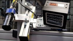 Figure 2: The industrial cameras from MATRIX VISION at the plant of the automotive supplier (Station 1). The figure shows the camera for detecting the bar code with a high-resolution camera lens. Infrared lighting was used during all criteria tests except the cable color test. The first advantage here is that the machine operators are not disturbed by the lighting flash since this takes place outside the human range of vision. Secondly, the combination with the utilized daylight cut filters in the industrial cameras almost totally excludes any outside light effect. Figure 2: The industrial cameras from MATRIX VISION at the plant of the automotive supplier (Station 1). The figure shows the camera for detecting the bar code with a high-resolution camera lens. Infrared lighting was used during all criteria tests except the cable color test. The first advantage here is that the machine operators are not disturbed by the lighting flash since this takes place outside the human range of vision. Secondly, the combination with the utilized daylight cut filters in the industrial cameras almost totally excludes any outside light effect.