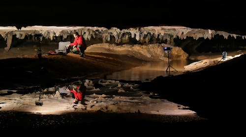 Photo by Alan Cressler shows Stephen Alvarez photographing ancient drawings in a cave in Alabama.