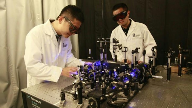 Researchers Xianglei Liu and Jinyang Liang working on the optical setup for their ultra high speed mapping camera.