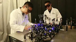 Researchers Xianglei Liu and Jinyang Liang working on the optical setup for their ultra high speed mapping camera.