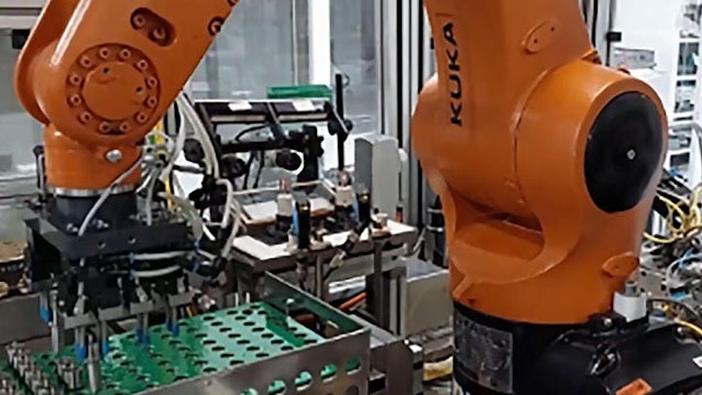Figure 1: An industrial robot at Bosch's plant in Curitiba, Brazil, picks up injector nozzles and places them on a platform, allowing a vision system to capture images of codes engraved on the nozzles.