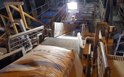 Figure 1: Three cameras are mounted above the production line to inspect the cement sacks. Two color cameras scan for defects such as splits, holes, cracks, and spills. A third monochrome camera (above) scans for printing errors. A DC LED light is also placed above the line to overcome ambient light issues. Figure 1: Three cameras are mounted above the production line to inspect the cement sacks. Two color cameras scan for defects such as splits, holes, cracks, and spills. A third monochrome camera (above) scans for printing errors. A DC LED light is also placed above the line to overcome ambient light issues.