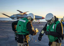 employees run diagnostics on the Boeing unmanned MQ-25 aircraft on flight deck